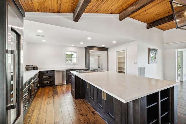 kitchen with dark hardwood / wood-style flooring, lofted ceiling with beams, a spacious island, wood ceiling, and appliances with stainless steel finishes