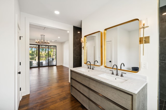 bathroom featuring hardwood / wood-style floors, vanity, and an inviting chandelier