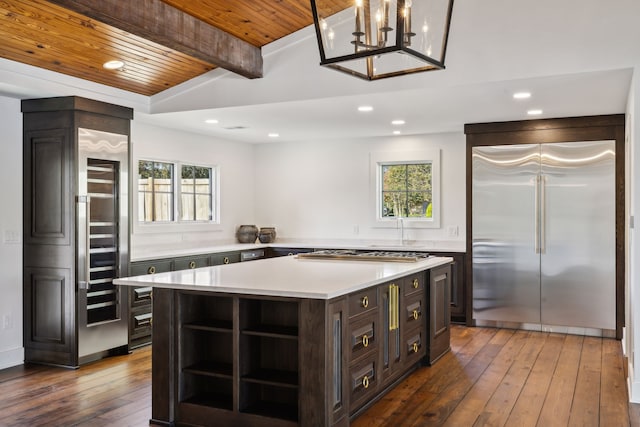 kitchen with stainless steel appliances, a kitchen island, plenty of natural light, and wooden ceiling