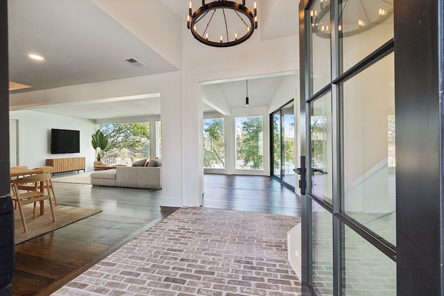 interior space with hardwood / wood-style flooring, french doors, and a chandelier