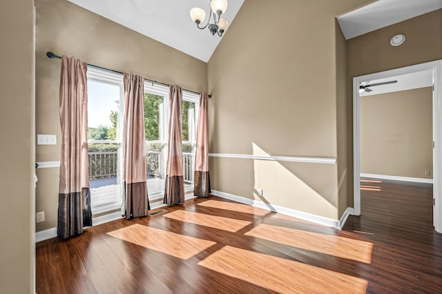 unfurnished room with hardwood / wood-style flooring, ceiling fan with notable chandelier, and vaulted ceiling