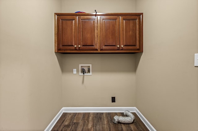 washroom featuring washer hookup, dark wood-type flooring, and cabinets