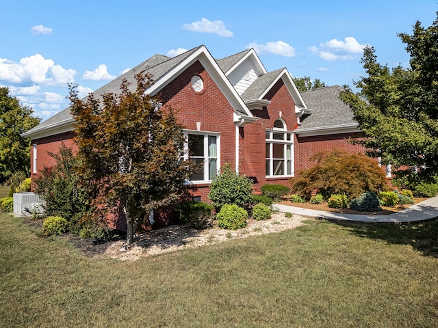 view of front of house with central AC unit and a front lawn