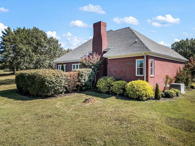 view of side of home featuring a yard and central air condition unit