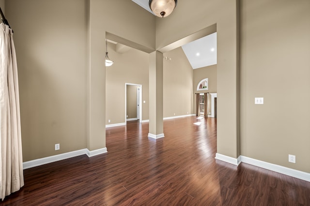 interior space with dark wood-type flooring and high vaulted ceiling