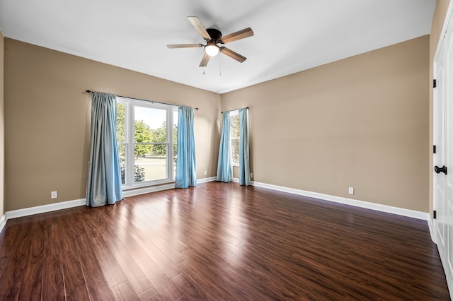 spare room with dark wood-type flooring and ceiling fan