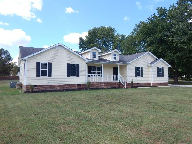 view of front of house featuring a front lawn, central air condition unit, and covered porch