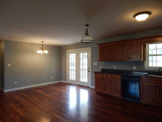 kitchen with black dishwasher, dark hardwood / wood-style flooring, pendant lighting, and a notable chandelier