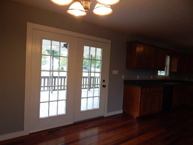 interior space with dark hardwood / wood-style floors, sink, and a notable chandelier