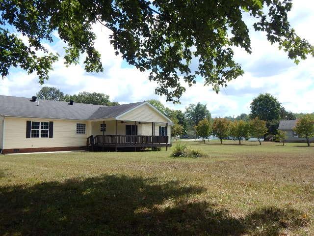 back of property featuring a lawn and a deck