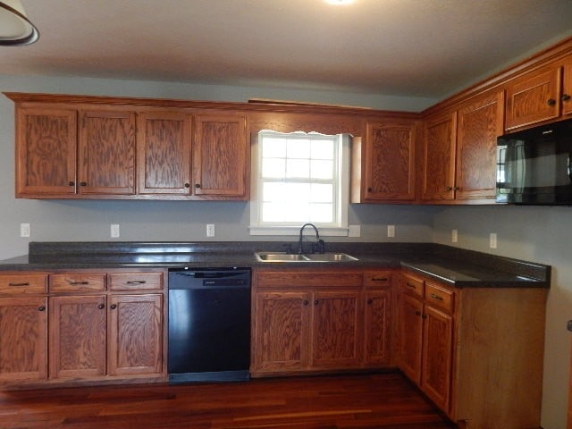 kitchen with black appliances, dark wood-type flooring, and sink