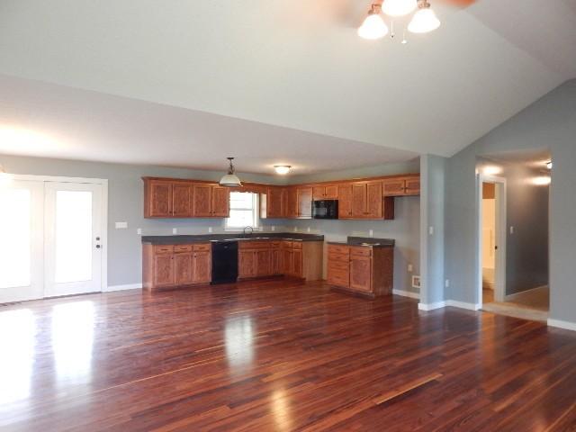 kitchen featuring lofted ceiling, black appliances, sink, and dark hardwood / wood-style flooring