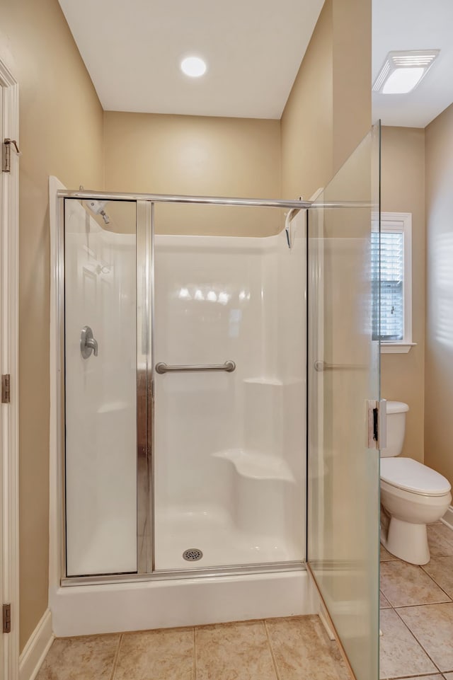 bathroom featuring tile patterned flooring, an enclosed shower, and toilet