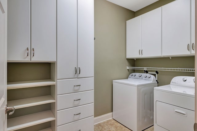 laundry area with cabinets, independent washer and dryer, and light tile patterned flooring