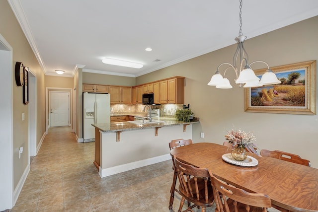 dining room featuring light tile patterned floors, a chandelier, sink, and crown molding