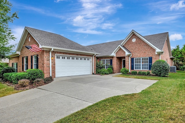 view of front of house with a garage, central air condition unit, and a front yard