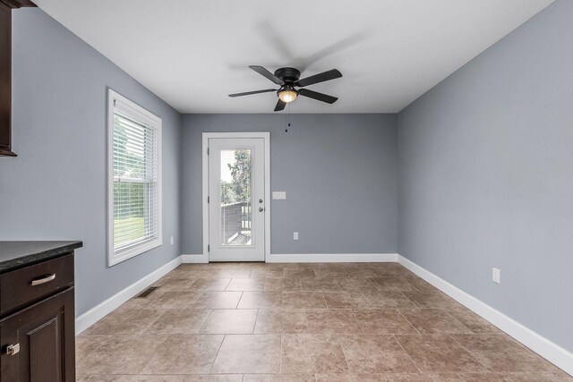 interior space with light tile patterned floors and ceiling fan