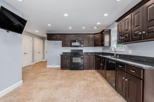 kitchen featuring dark brown cabinets, black appliances, sink, and dark stone counters