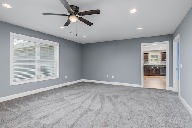 unfurnished room featuring light carpet and ceiling fan