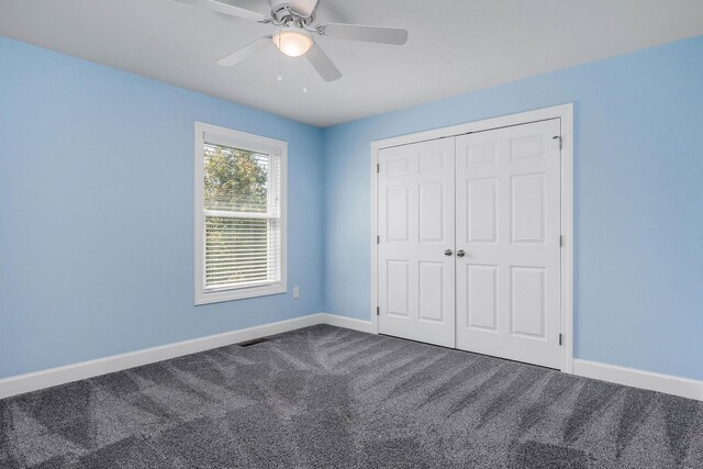 unfurnished bedroom featuring carpet floors, a closet, and ceiling fan