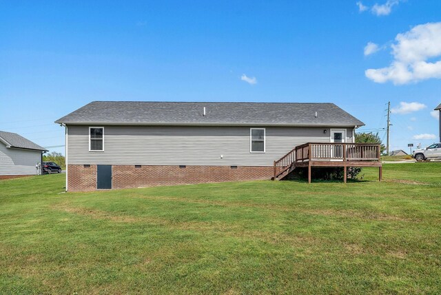 rear view of house with a wooden deck and a yard