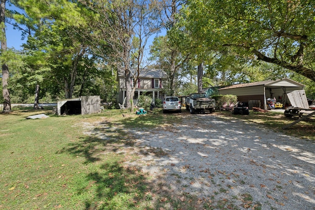 exterior space featuring a front yard, an outdoor structure, and a carport