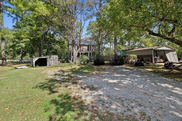 view of yard featuring a carport and an outbuilding