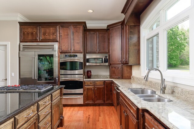 kitchen with light stone countertops, sink, and stainless steel appliances