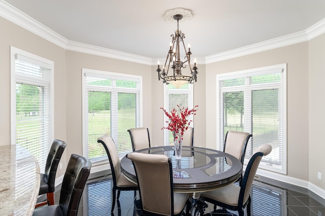 dining room featuring a notable chandelier, ornamental molding, and dark tile patterned floors