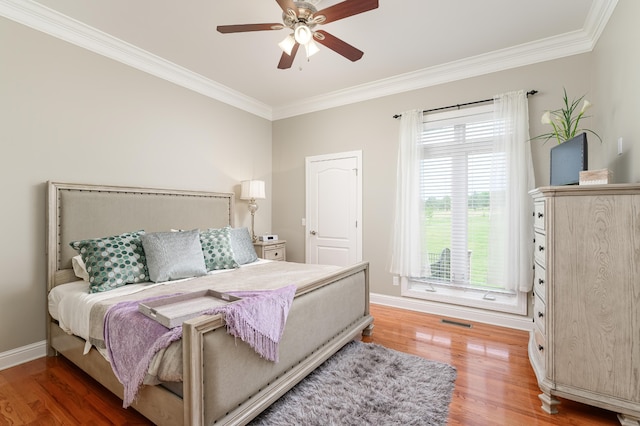 bedroom featuring crown molding, hardwood / wood-style floors, and ceiling fan