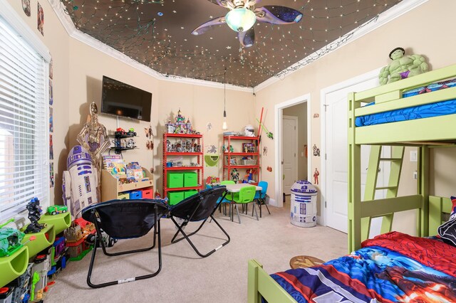 playroom featuring carpet floors, ornamental molding, and ceiling fan