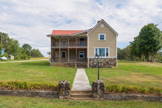 view of front facade featuring a balcony and a front yard