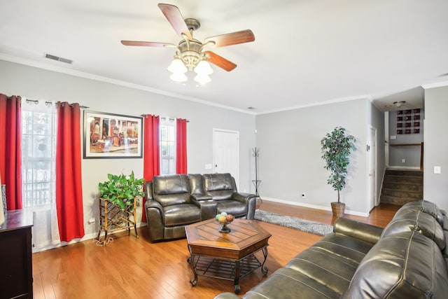 living room featuring ornamental molding, wood-type flooring, and ceiling fan