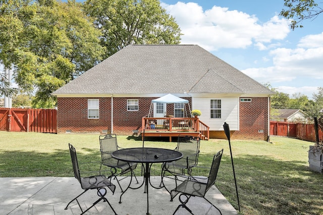 rear view of property featuring a patio, a yard, and a wooden deck