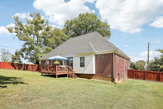 rear view of property featuring a wooden deck and a yard