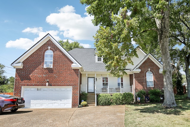 front facade featuring a front lawn, covered porch, and a garage