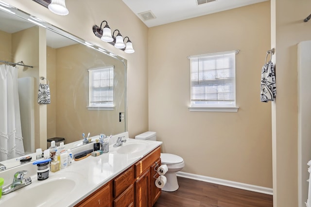 bathroom featuring vanity, toilet, wood-type flooring, and walk in shower