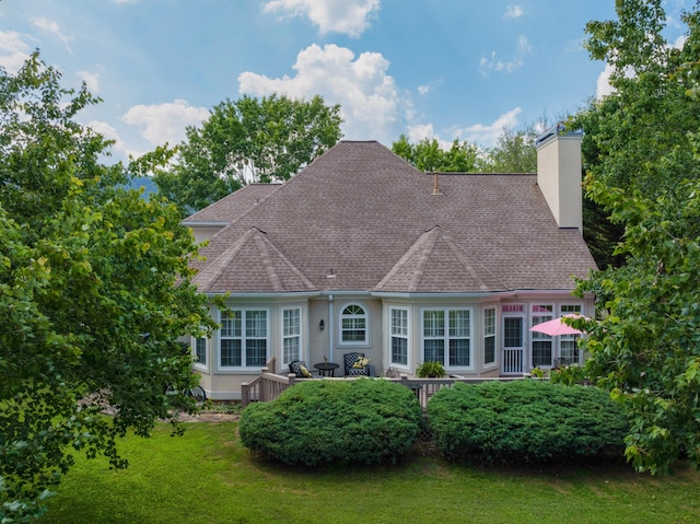 rear view of property featuring a wooden deck and a yard