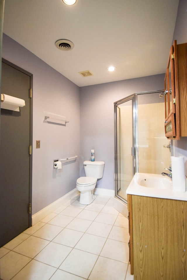 bathroom with tile patterned flooring, walk in shower, vanity, and toilet