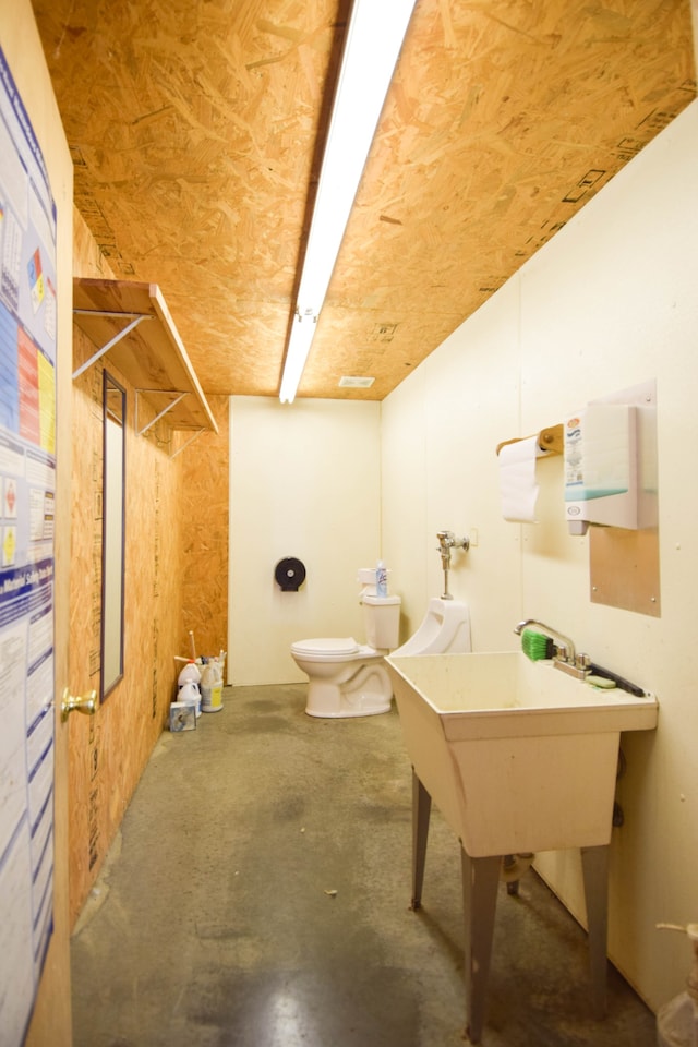 bathroom with concrete flooring and toilet