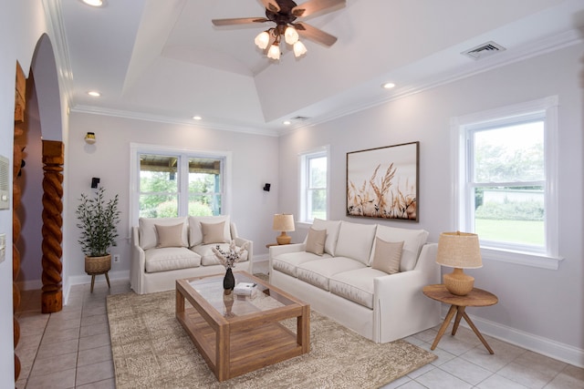 tiled living room with ceiling fan, a raised ceiling, and ornamental molding