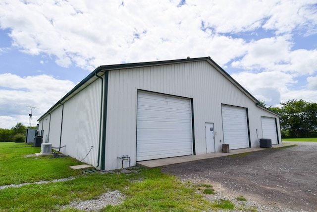 garage featuring cooling unit and a yard