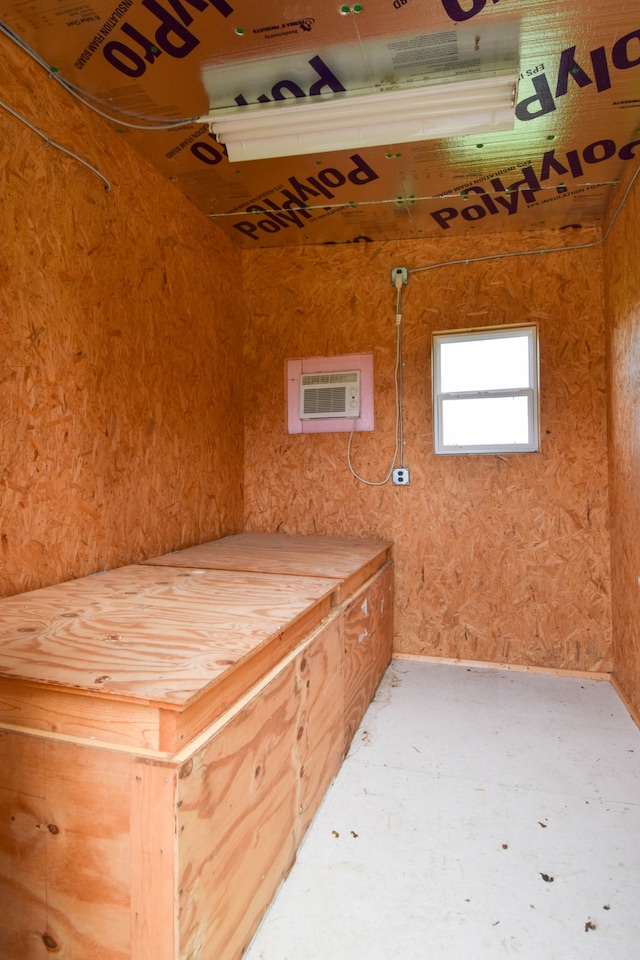 interior space with an AC wall unit and concrete floors