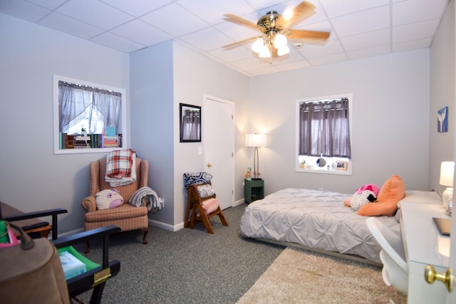 bedroom featuring carpet flooring, ceiling fan, and a drop ceiling