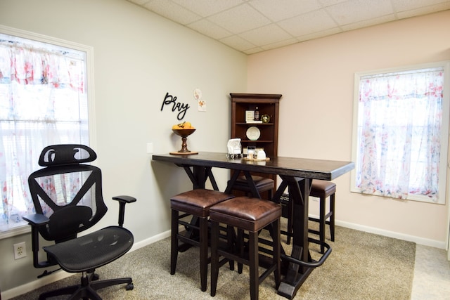 carpeted dining room featuring a drop ceiling