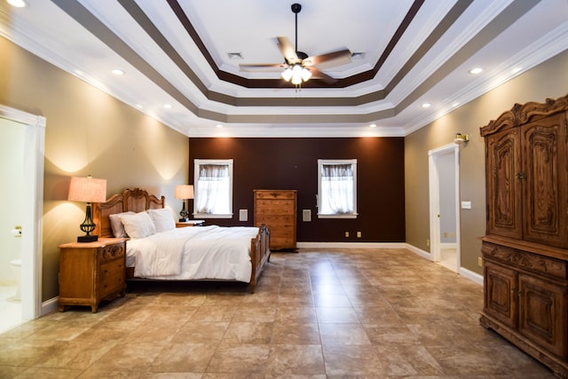 bedroom featuring ceiling fan, connected bathroom, a raised ceiling, and crown molding