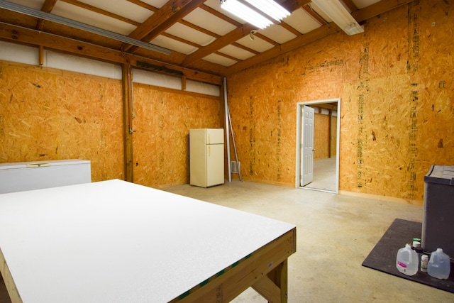 interior space featuring white refrigerator and concrete floors