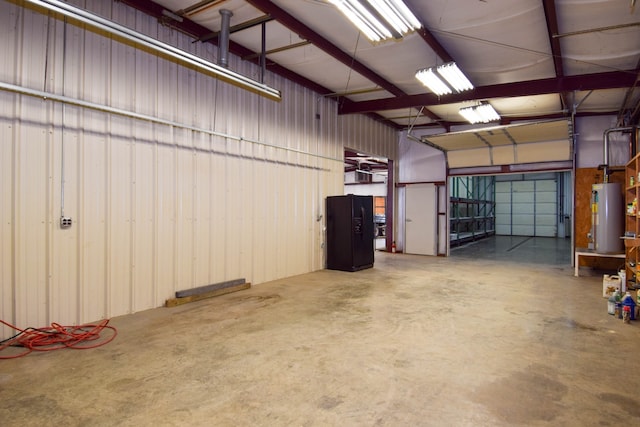 garage with gas water heater and black fridge with ice dispenser