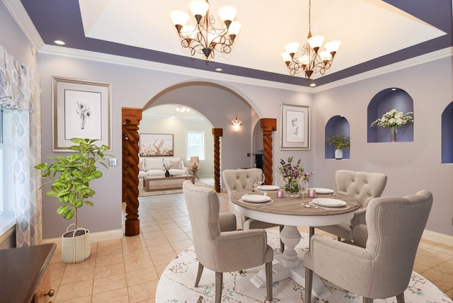 dining space with crown molding, light tile patterned flooring, a tray ceiling, and a notable chandelier