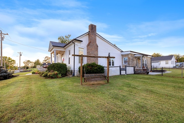 view of side of home with a chimney, a pergola, fence, and a yard
